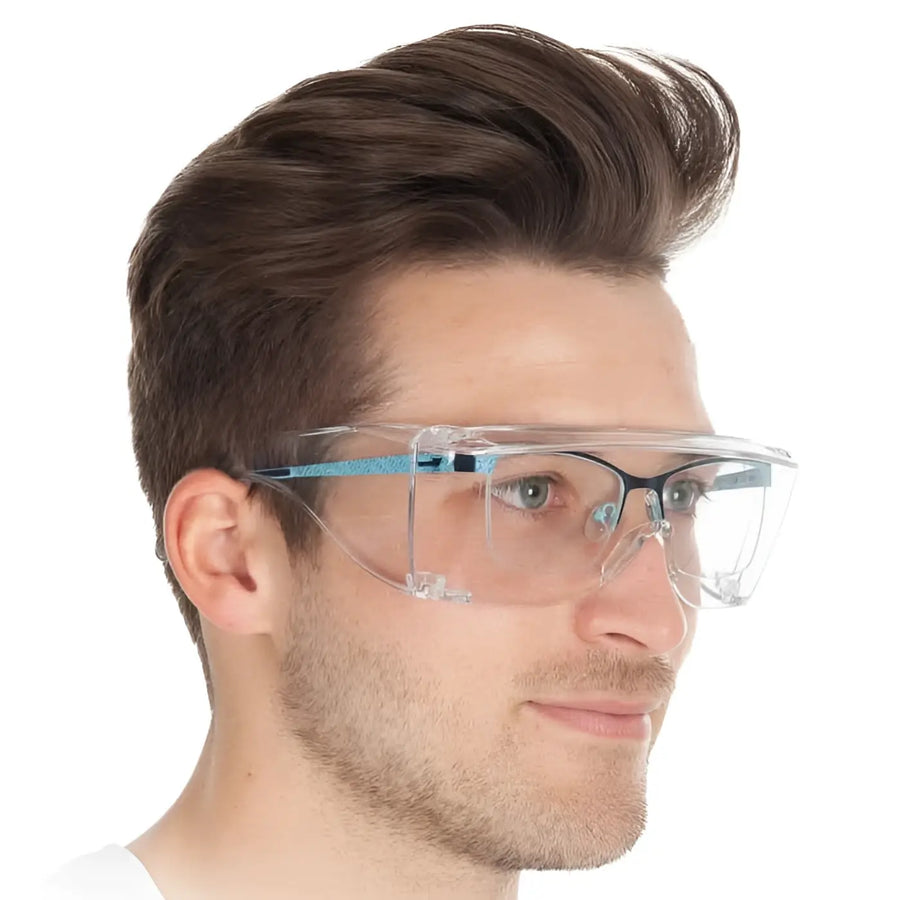 Klarer augenschutz mit blau schwarzem rahmen aus kunststoff getragen von einem mann