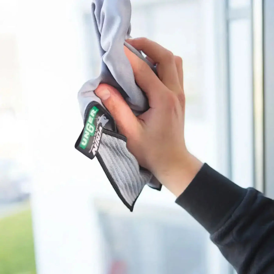 Graues mikrofaser-reinigungstuch mit schwarzem rand und grünem duster ninja markenetikett aus der fenstertuch kollektion