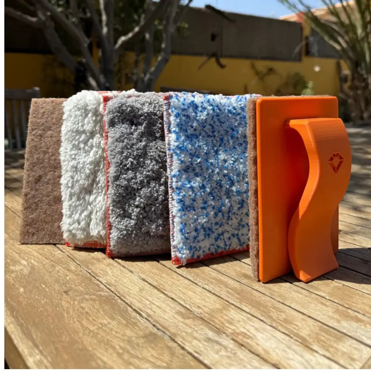 Orange plastikschwammhalter mit vier verschieden strukturierten reinigungspads in braun, weiß, grau und blau, maykker jitterbug schrubber inkl walnusspad 15cm