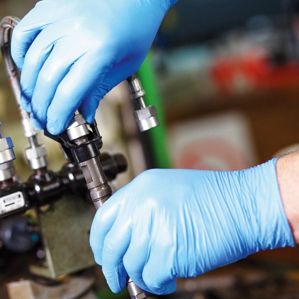 Hände mit Hygonorm "Safe Fit" Nitril-Handschuhe Blau 200 Stück von Franz Mensch bei technischer Arbeit getragen
