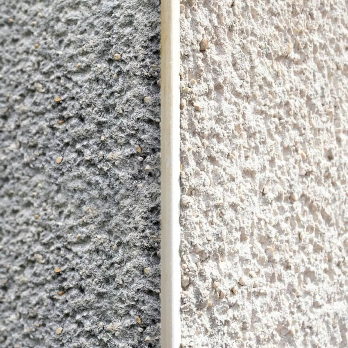 Ein schlanker offwhite alkaliStar 5 konzentratsstreifen aus glattem material an der naht zweier strukturierter stucco-wände