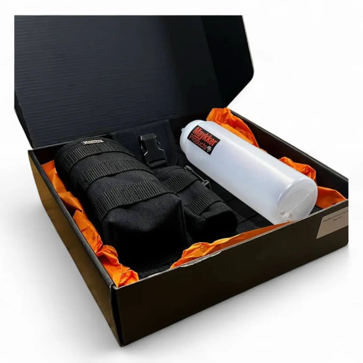 Schwarzes taktisches tragetasche mit verstellbaren riemen und schwarzem schnallen neben weißer plastikflasche von maykler products im maykker covert trio set