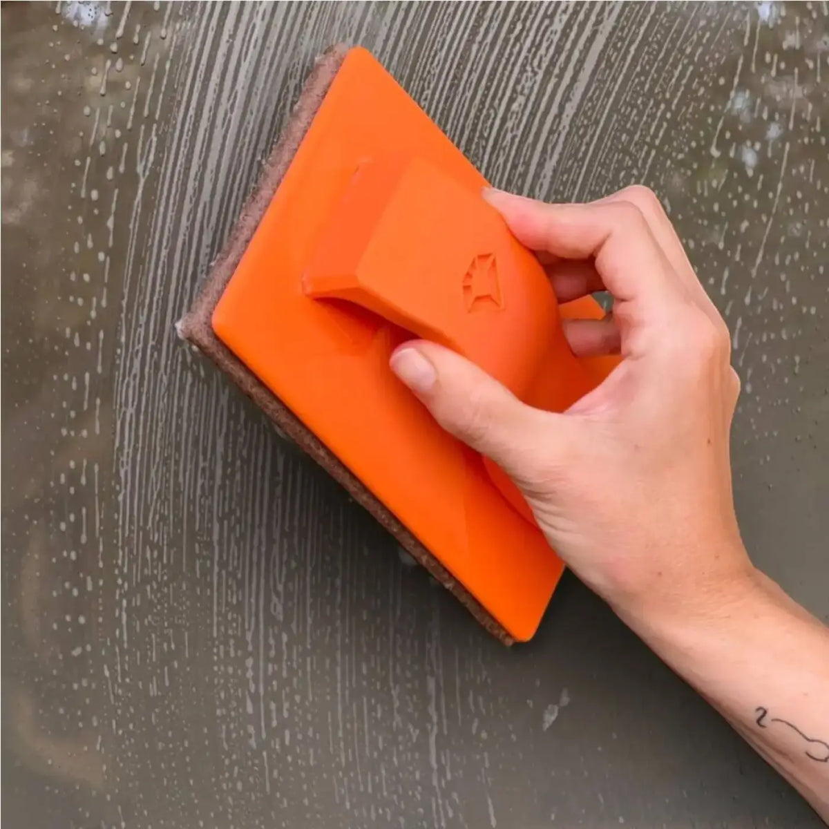 Orange rechteckiger maykker jitterbug schrubber mit strukturierter oberfläche und brauner scheuerseite mit logo