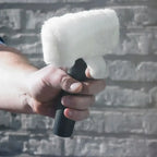 Weißes flauschiges mikrofonwindschutz mit schwarzem griff gehalten in der hand für moerman click & scrub reinigungspad