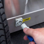 Weißer kunststoffstecker mit blauem griff wird in steckdose eines edelstahlgeräts des osmobil pro x eingeführt