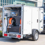 Weißer osmobil trailer v2 utility anhänger mit silbernem rahmen und orangen schweißschläuchen innen industrialausrüstung