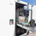 Silberne edelstahl qmobil pro x tragbare wasserpumpe mit messingarmaturen und schwarzer tasche auf osmobil trailer v2 anhängersystem