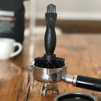 Schwarze sauba siebträgerbürste siba mit nylonborsten im metallsiebträger für reinigung von kaffeefiltern