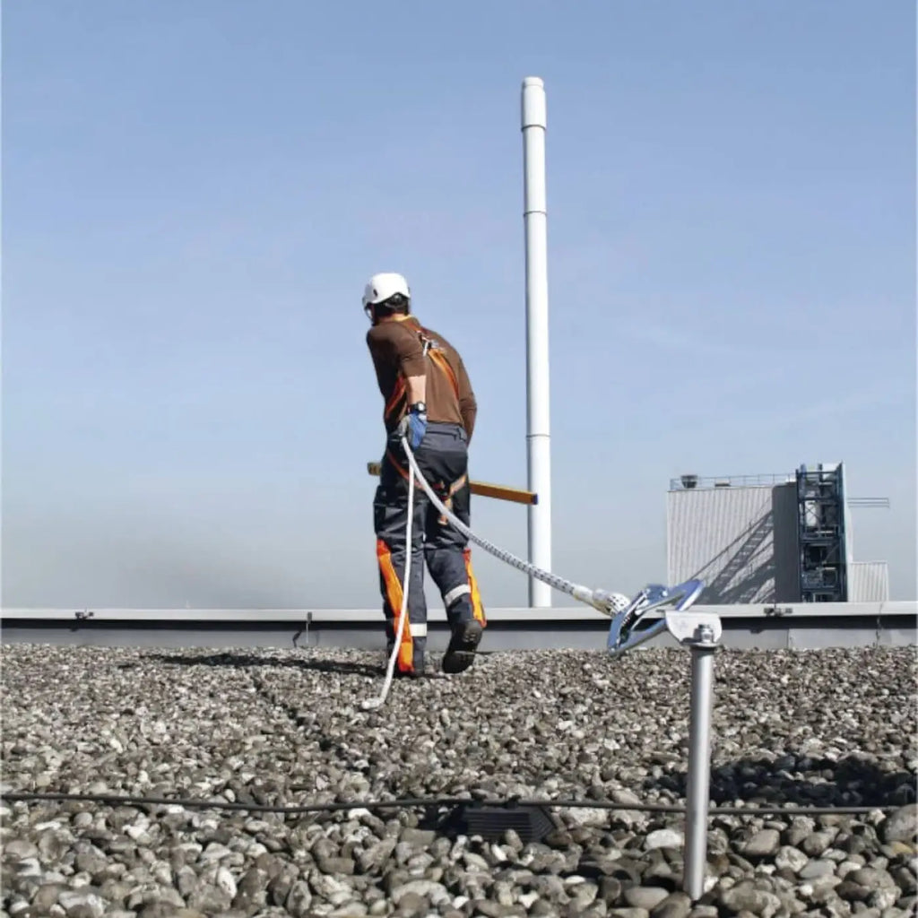 Arbeiter mit weißem helm und orange-grauem sicherheitsgeschirr skylotec arg 30 auffanggurt auf kiesdach
