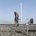 Arbeiter mit weißem helm und orange-grauem sicherheitsgeschirr skylotec arg 30 auffanggurt auf kiesdach