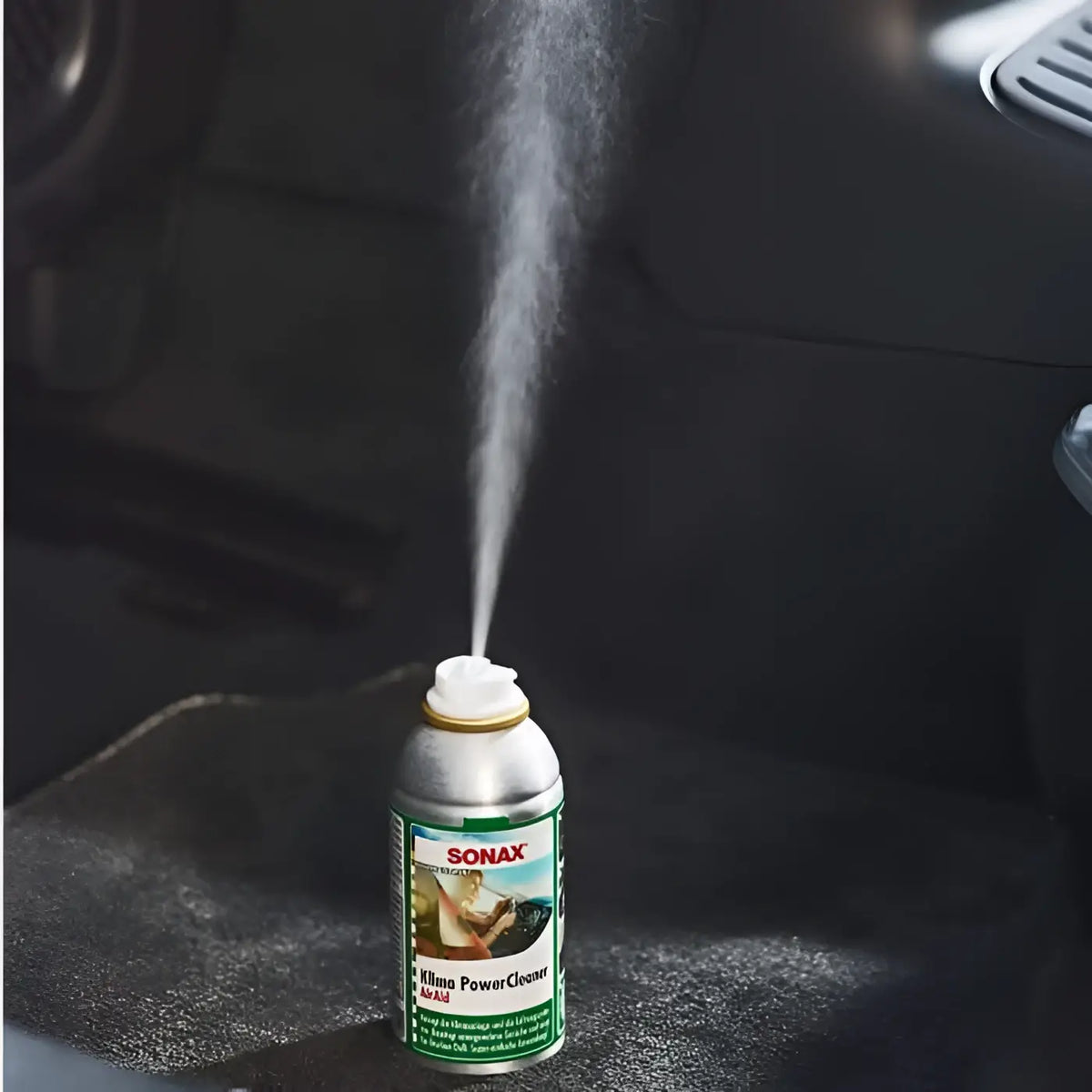 Ein silberner aerosolbehälter von sonax klima powerclean air aid mit grünem und weißem schriftzug 100ml