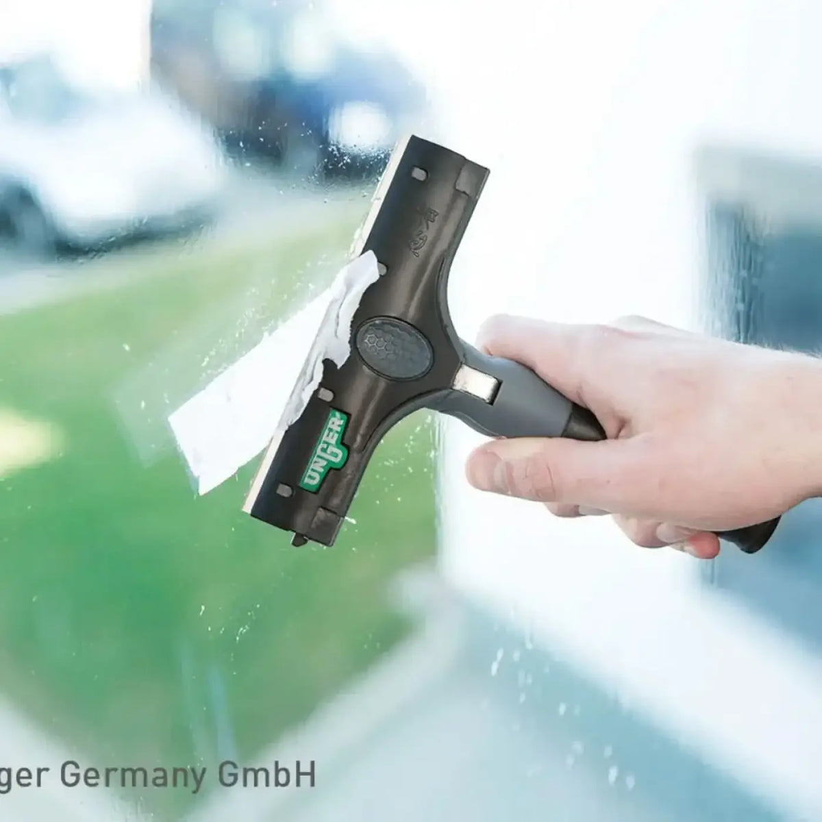 Black und grau unger ergotec ninja schaber fensterabzieher mit weißem mikrofaser tuch an der klinge