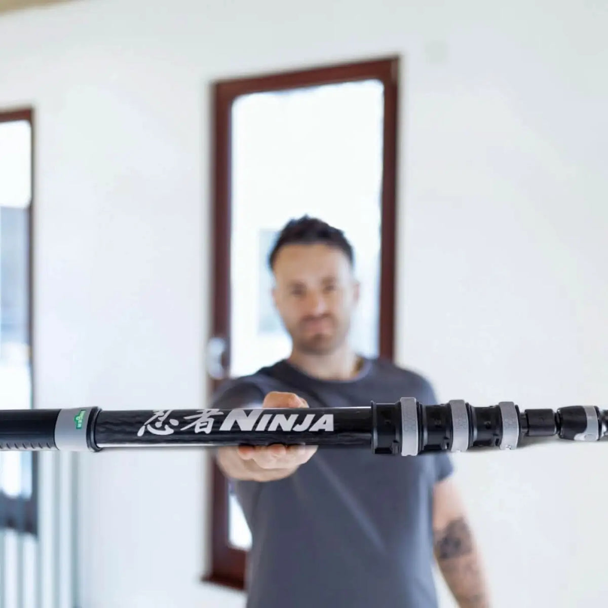 Schwarzer und silberner ausziehbarer carbon-moppstiel mit ninja branding für das unger ninja 6in1 glasreinigungsset