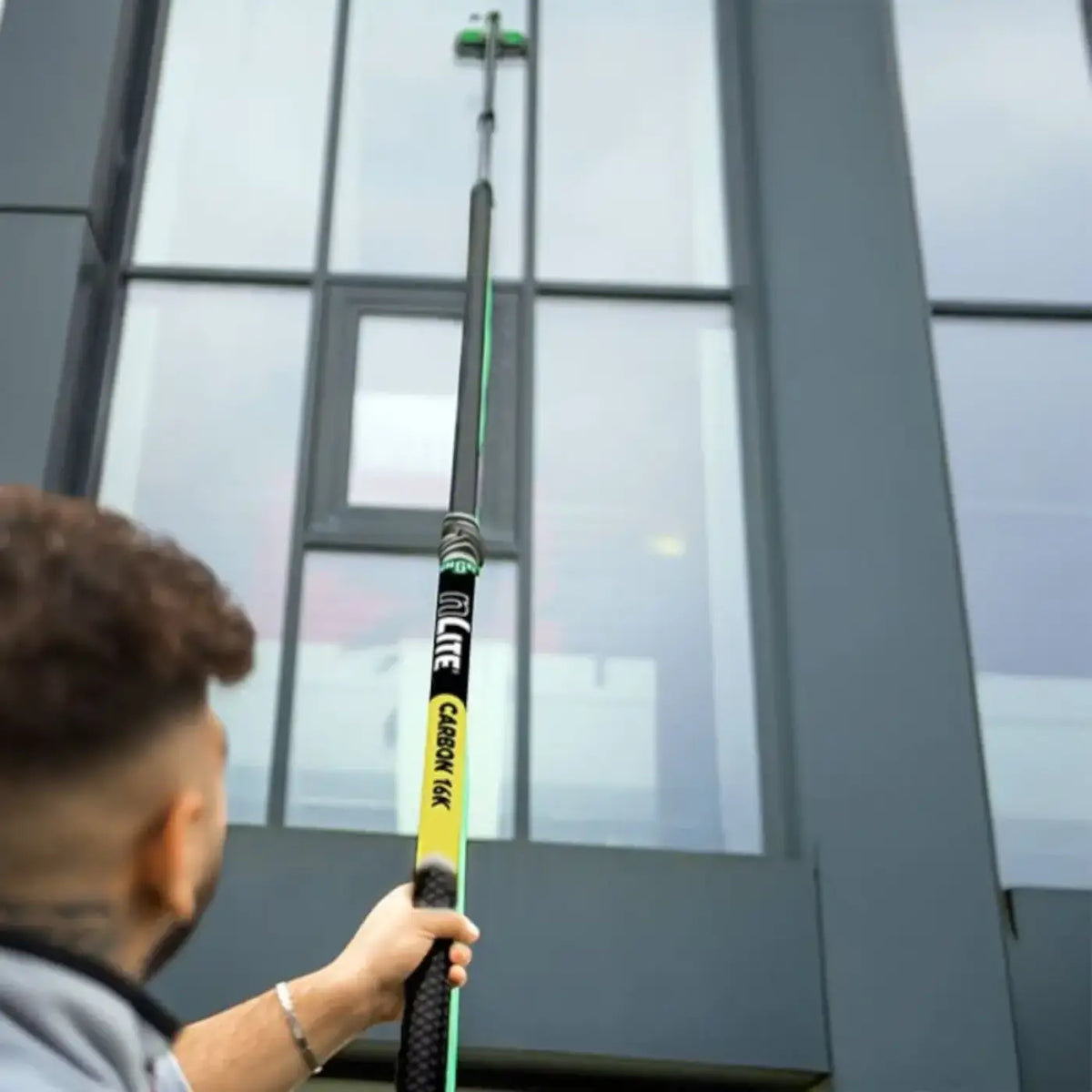 Schwarze und grüne unger nLite carbon 16k teleskopstange mit gelbem caboon 16k label zum fensterputzen